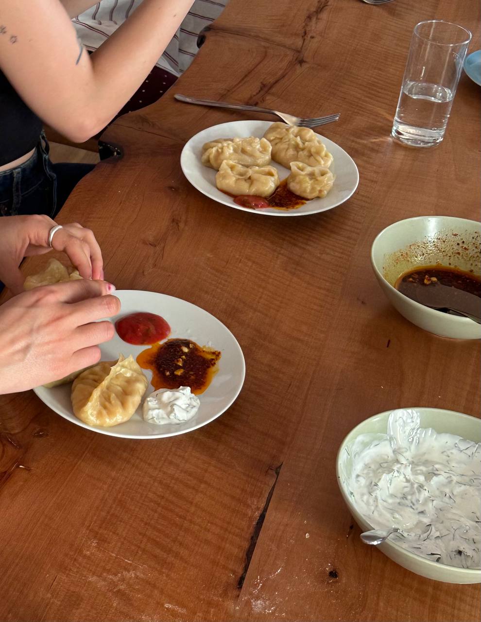 Freshly steamed manty served with tomato sauce, chili oil and dill yogurt